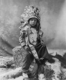   , faicng slightly right; wearing feathered headdress and beaded vest