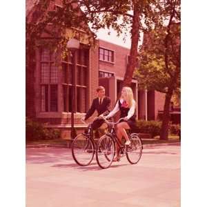 Teenage Couple Riding Bicycles Past High School Buildings Photographic 